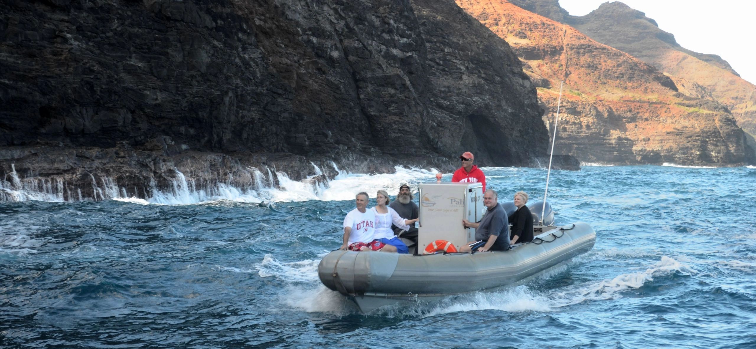 A complete Zodiac raft traveling below the Na Pali cliffs